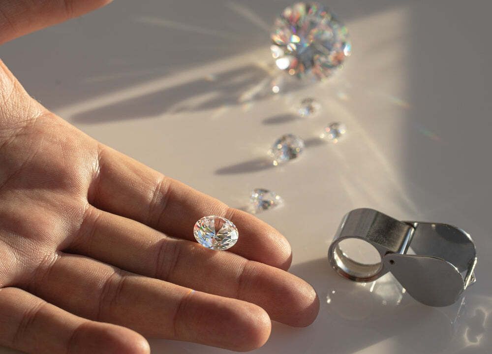Hand holding raw diamond under sunlight